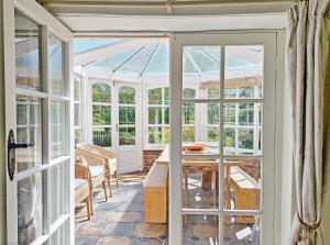 a conservatory with a glass door and a table at The Milk House in Ashurst