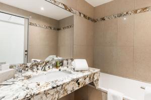 y baño con lavabo de mármol y bañera. en Logis L'Auberge - Maison Glenn Anna, en Sainte-Anne-d'Auray