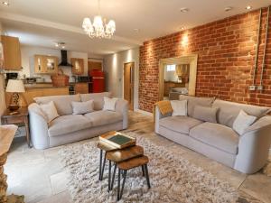 a living room with two couches and a brick wall at The Fullerton in Longwitton