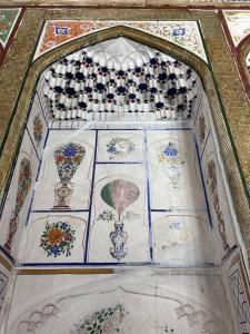 a room with a painting of clocks on the ceiling at Hotel Zuxritdin with XIX century museum in Bukhara