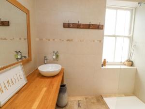 a bathroom with a sink and a mirror at The Fullerton in Longwitton +14 photos