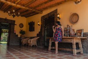a woman in a dress talking on a cell phone at Hotel Fundo San Rafael in Nazca