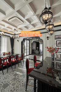 下龍灣的住宿－Villa Hạ Long Gần Biển，一间带桌子和红色椅子的用餐室