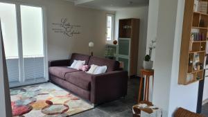 a living room with a brown couch with pillows at Ferienwohnung Wurzelecht in Bad Neuenahr-Ahrweiler