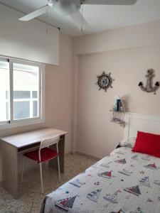 a bedroom with a bed and a desk and a window at Torrenueva Playa in Torrenueva