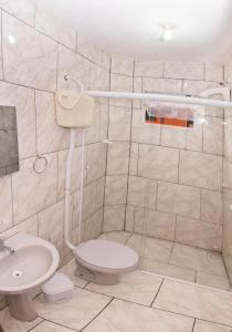 a bathroom with a toilet and a sink at Pousada Esperança in Penha