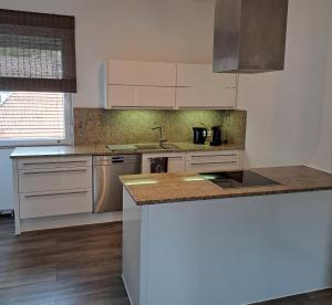 a kitchen with white cabinets and a counter top at Ferienwohnung Paulus in Albstadt