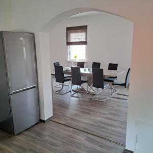 d'une salle à manger avec une table, des chaises et un réfrigérateur. dans l'établissement Ferienwohnung Paulus, à Albstadt