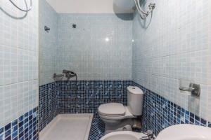 un bagno piastrellato blu con un water e un lavandino di Cozy Seaside by PS a Golem Altre 18 foto