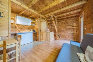 a kitchen and dining room with a wooden wall at Pensjonat Kwiatkowski domek nr 1 in Nowęcin