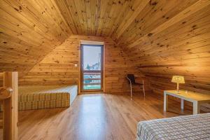 a log cabin with a room with two beds and a window at Pensjonat Kwiatkowski domek nr 1 in Nowęcin