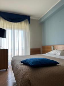 a bedroom with a blue pillow on a bed at Hotel Lachea in Acitrezza