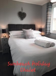 um quarto com uma cama com duas toalhas em Sunbeach Holiday Chalet, California, Norfolk - Sleeps up to 5 people, Bedding & Towels Included, Club House & Pool Included em Scratby