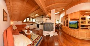 a large living room with a couch and a tv at Apartments Rezia in Ortisei