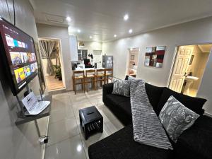 a living room with a couch and a kitchen at Lincoln Moon Guesthouse in Graskop