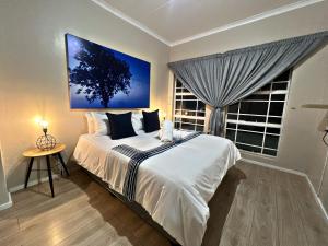 Un dormitorio con una cama grande y una ventana en Lincoln Moon Guesthouse en Graskop