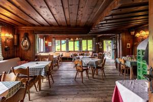 a restaurant with wooden floors and tables and chairs at Berghotel Breitmoos in Mittersill