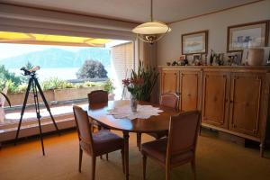 uma sala de jantar com mesa e cadeiras e uma grande janela em Charming Apartment w/Terrace on Lake and Mountain em Weggis