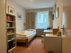 1 dormitorio con cama, escritorio y ventana en Charming Apartment w/Terrace on Lake and Mountain en Weggis