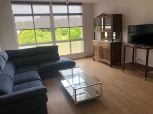 a living room with a blue couch and a glass coffee table at Casa Aricel VT in Chantada