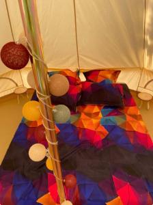a multicolored comforter on a bed under an umbrella at Delta Dunarii - Casa de langa apa in Ilganii de Sus