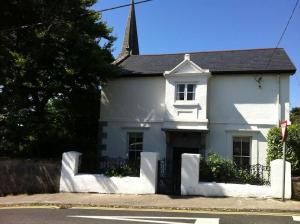 una casa blanca sentada al lado de una calle en Hill House Clifden, en Clifden