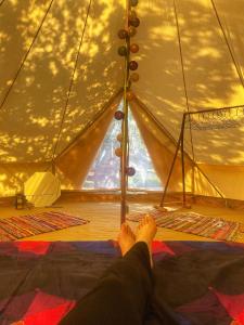 d'une personne debout dans une tente avec les pieds en haut dans l'établissement Delta Dunarii - Casa de langa apa, à Ilganii de Sus