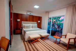 a hotel room with a bed and a balcony at Ananda Pousada in Pirenópolis