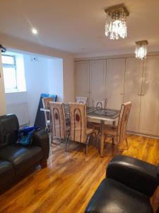 een woonkamer met een eettafel en stoelen bij Rayan's Lodge Stratford London by OYO in Londen