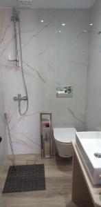 een badkamer met een wastafel, een bad en een toilet bij Pension Patelo in Pitsidia