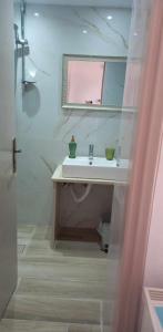 uma casa de banho com um lavatório e um espelho em Pension Patelo em Pitsídia