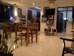 a dining room with a wooden table and chairs at Puri Mandhara Lovina in Lovina