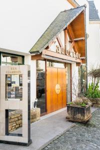 a building with a wooden door in front of it at Logis L'Auberge - Maison Glenn Anna in Sainte Anne d'Auray 