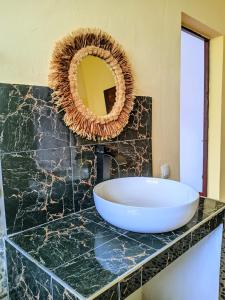 a bathroom with a sink and a mirror on a counter at Villa Soa in Ile aux Nattes
