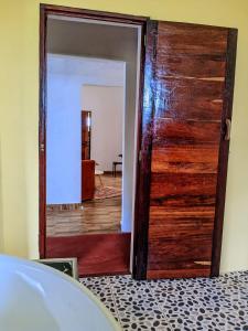 a wooden door in a room with a mirror at Villa Soa in Ile aux Nattes