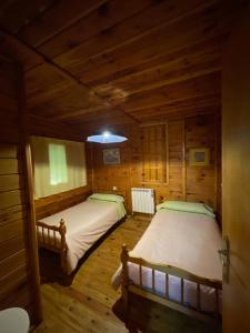 two beds in a room with wooden floors at Cabañas de Nerpio in Nerpio
