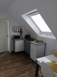 a kitchen with a skylight and a kitchen with a table at Apartments Mohrini in Berlin