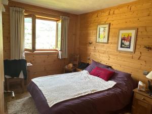 a bedroom with a bed in a wooden room at Chalet familial sur les pistes in Megève