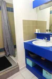 y baño con lavabo azul y ducha. en Appartement terrasse , vue sur piscine Montagne !! Incroyable !, en Argelès-sur-Mer