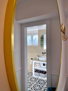 ein Badezimmer mit Spiegel und Waschbecken in der Unterkunft Cloos - Elegant Residence with Panoramic View in Braşov + 34 Fotos