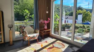 a screened in porch with a chair and a vase of flowers at Ferienwohnung Wurzelecht in Bad Neuenahr-Ahrweiler