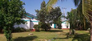 un edificio blanco y azul con árboles delante en KANAMAI PRIME VILLAS, en Mombasa