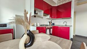 een keuken met rode kasten en een tafel met een vaas bij Happy House - Marina Centro in Rimini