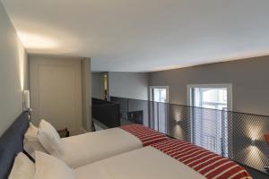 a hotel room with a bed, chair, and nightstand at Oporto Serviced Apartments - 1858 in Porto