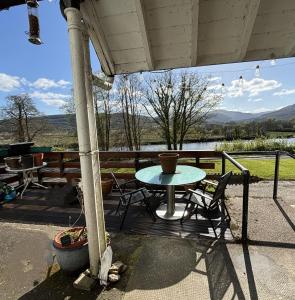 a table and chairs on a porch with a view at North Lodge Kilmun in Kilmun