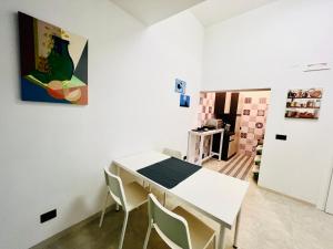 a dining room with a white table and chairs at B&B Margherita Torremaggiore in Torre Maggiore