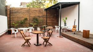 a patio with tables and chairs and a guitar at Habitación en Palermo in Buenos Aires