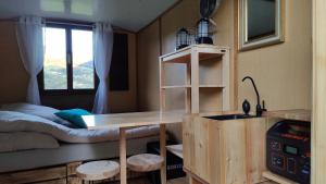 a small room with a bed and a desk and a sink at Schäferhütte in Krispl