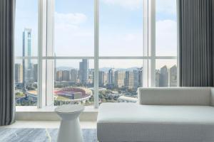 a living room with a white couch and a large window at Sheraton Guangzhou Hotel in Guangzhou
