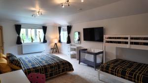 um quarto com 2 camas e uma televisão de ecrã plano em Henley-in-Arden Family Mansion em Henley in Arden